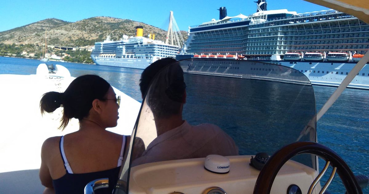 Guests on a small boat in Gruž harbour, with cruise ships moored behind