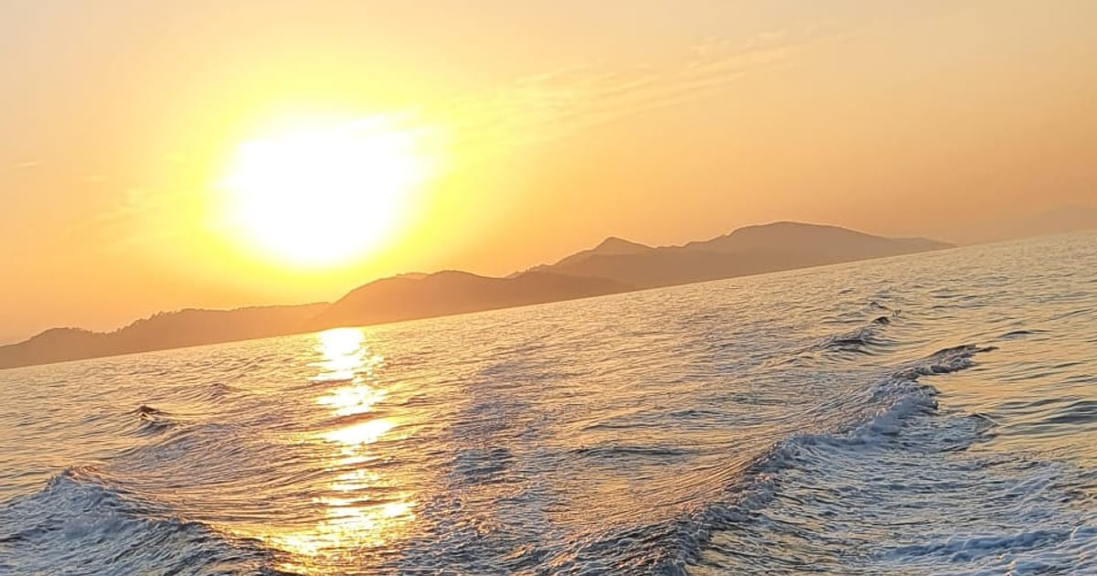 Low sun over the islands and the white wake behind the boat